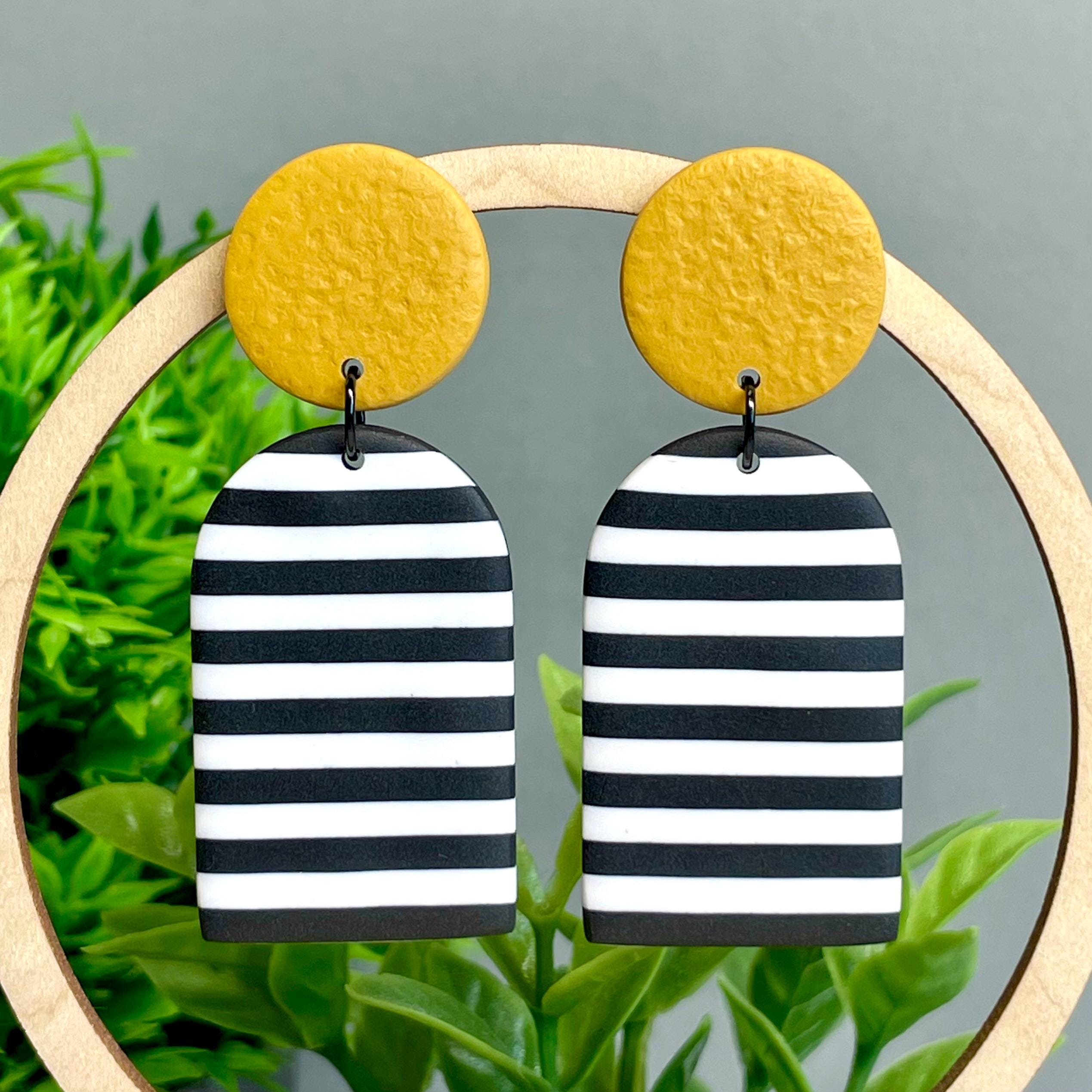 Black and white striped earrings with mustard yellow circular tops