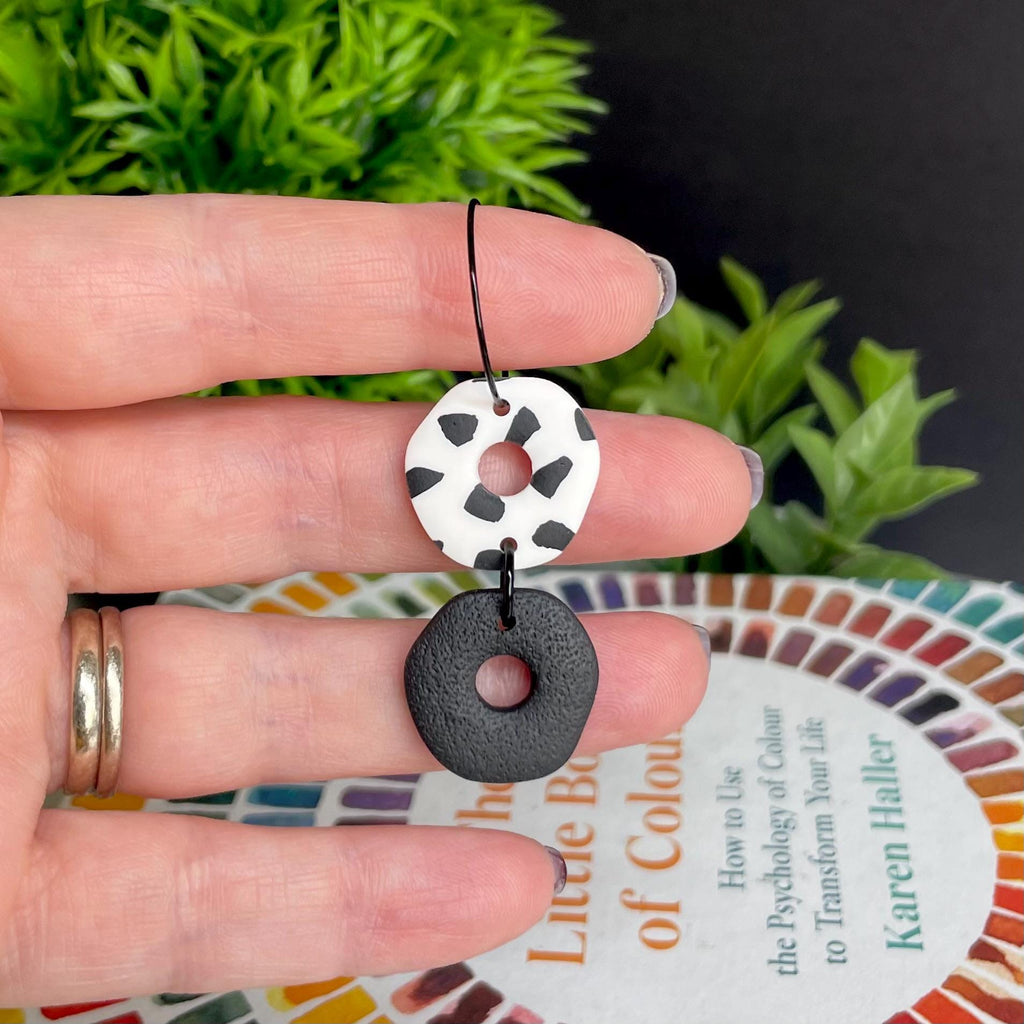 Hand holding a Black & white Dalmatian print hoop earring
