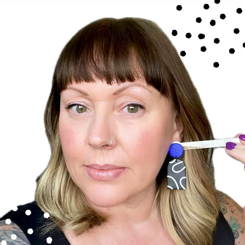 Try on picture of Kerry from Kay Jay Clay wearing the monochrome squiggle dangle earrings with an electric blue top for size reference