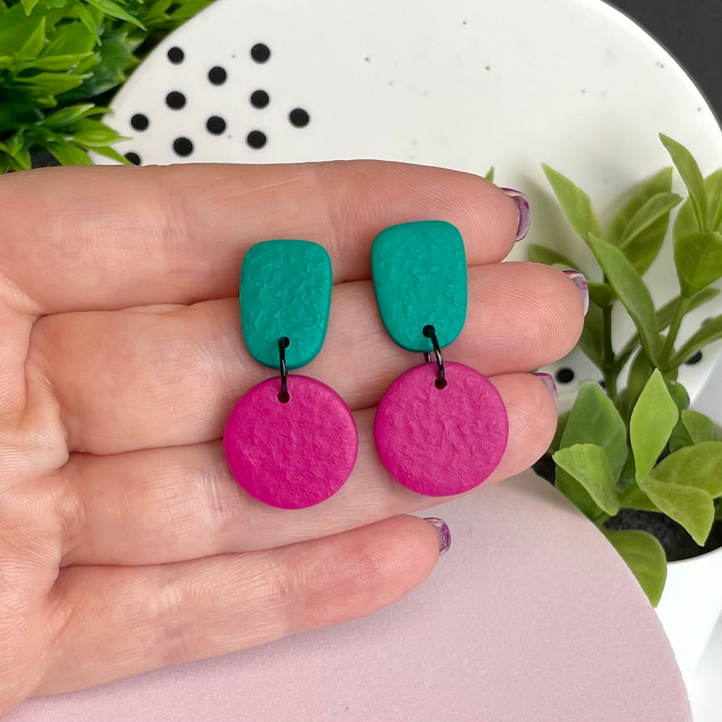 Emerald Green & Hot Pink colour pop dangle earrings held in hand for size reference