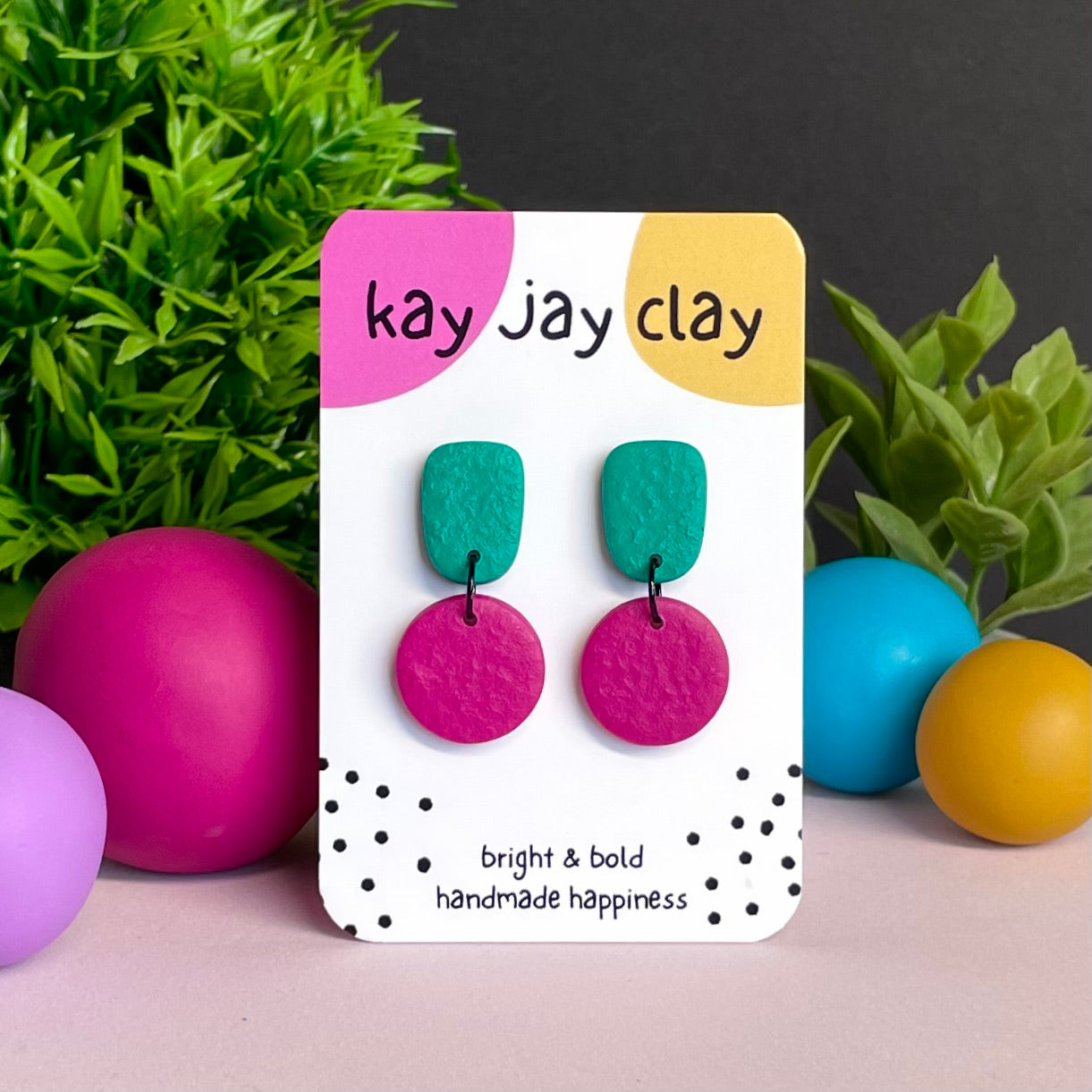 Emerald Green & Hot Pink colour pop dangle earrings on Kay Jay Clay branded mounting card