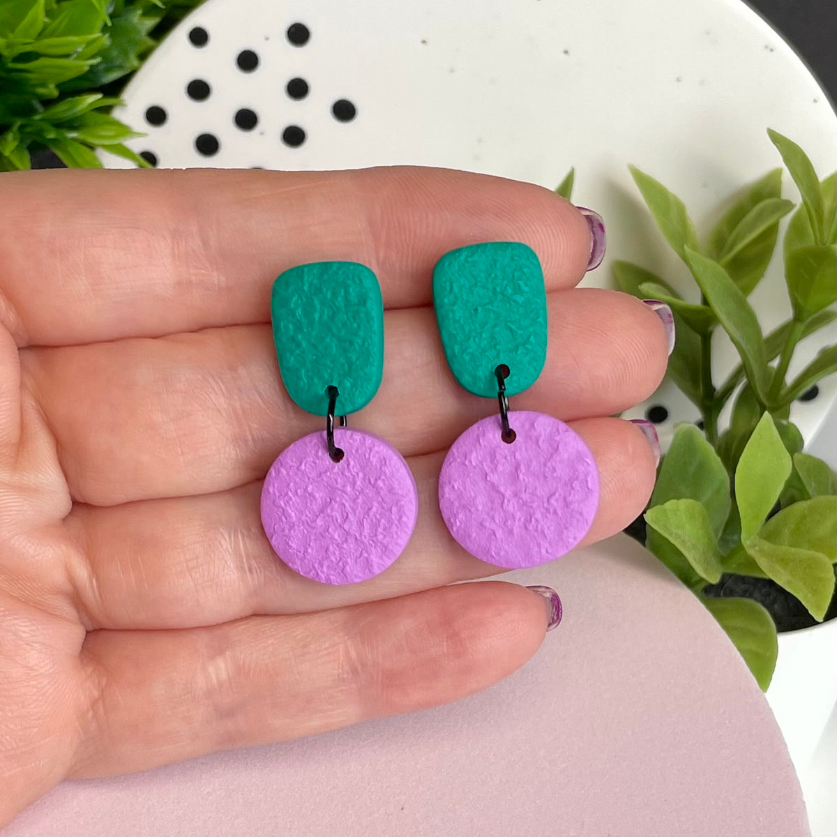 Emerald Green & Lilac colour pop dangle earrings held in hand for size reference