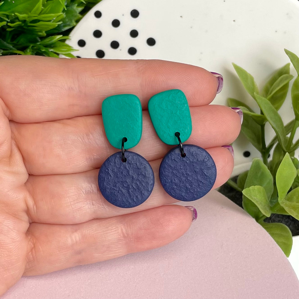 Emerald Green & Navy Blue colour pop dangle earrings held in hand for size reference