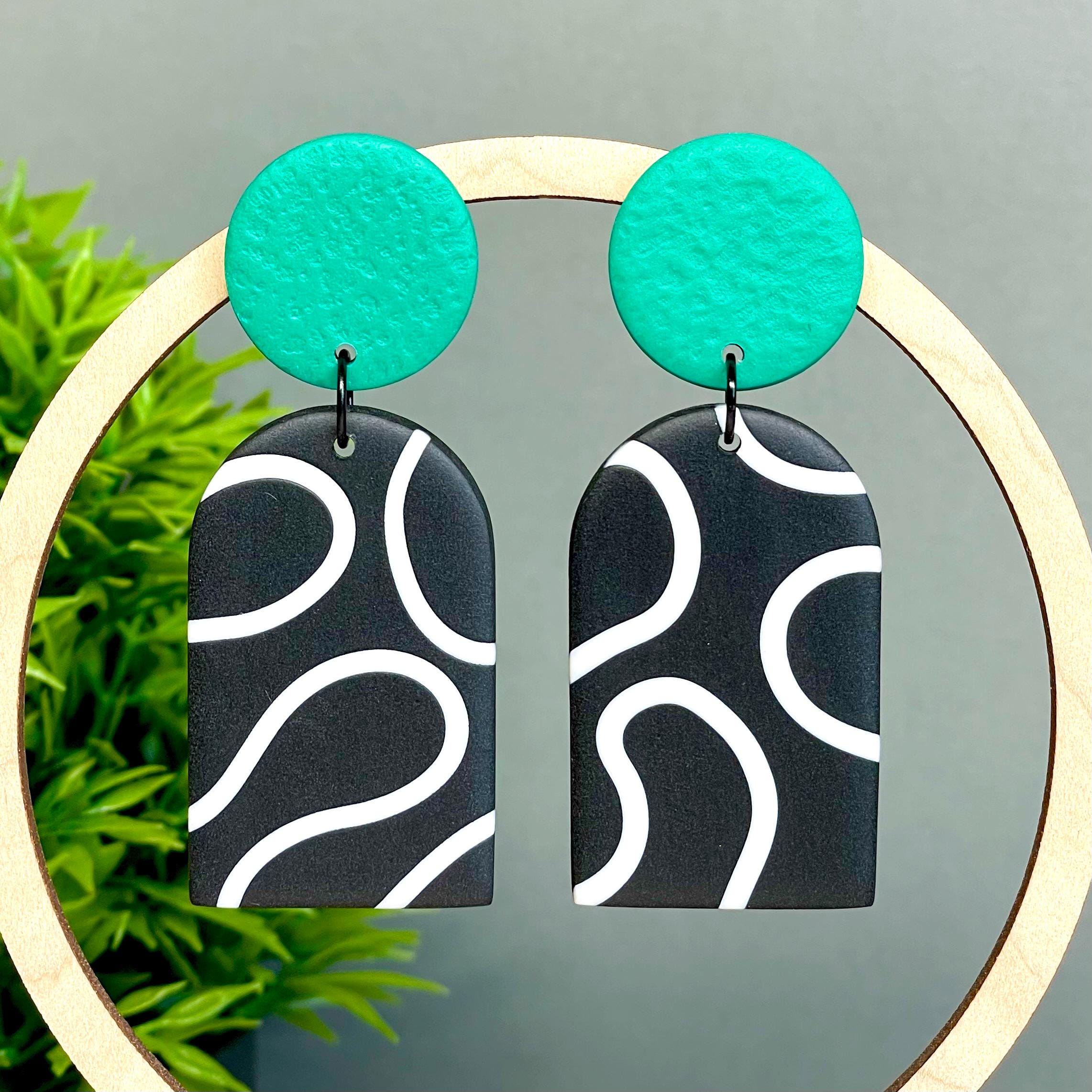 Black and white squiggle patterned earrings with emerald green circular tops 
