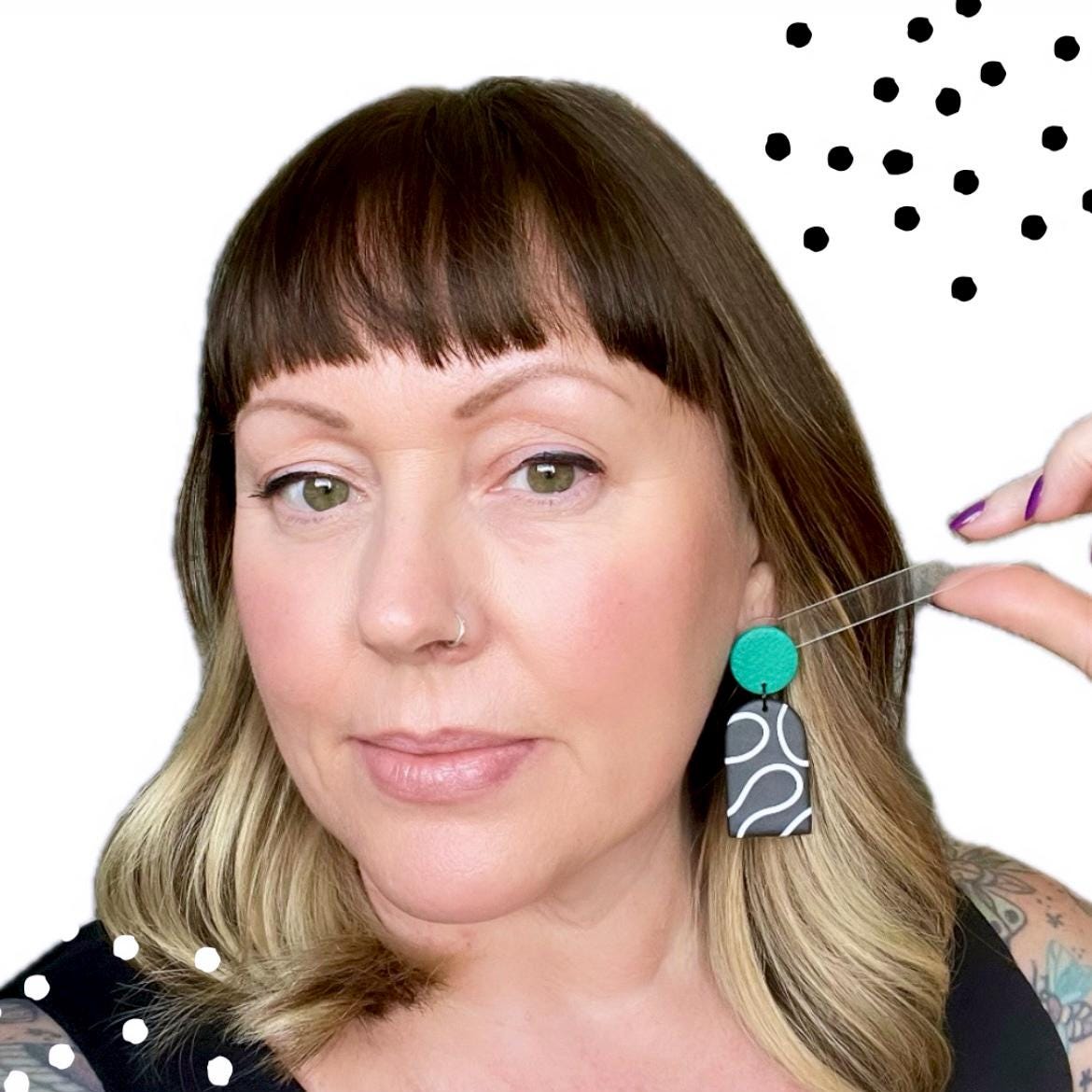 Try on picture of Kerry from Kay Jay Clay wearing the monochrome squiggle dangle earrings with an emerald green top for size reference