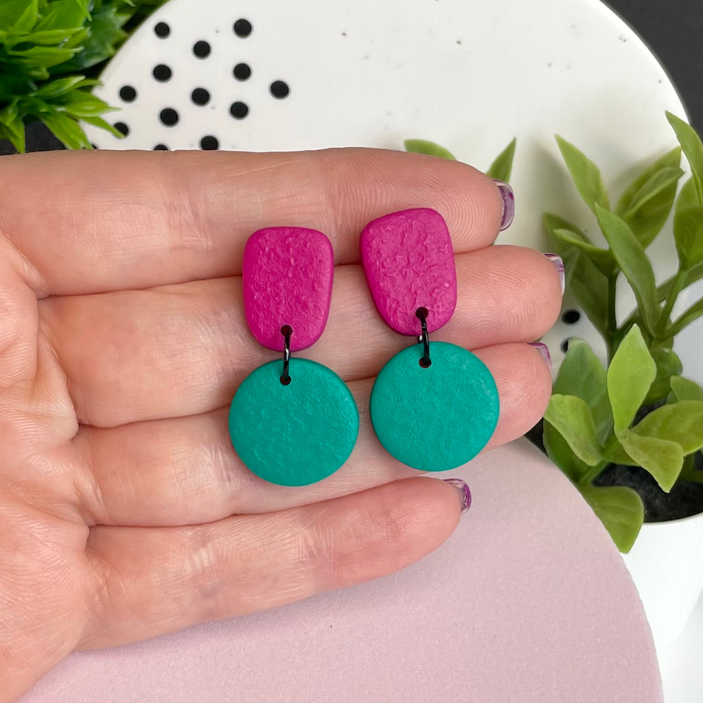 Hot Pink & Emerald Green colour pop dangle earrings held in hand for size reference