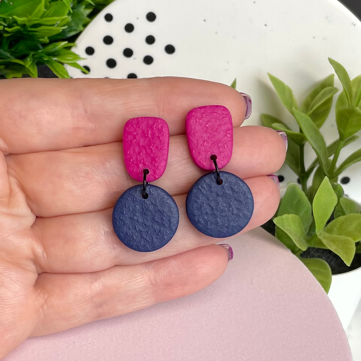 Hot Pink & Navy Blue colour pop dangle earrings held in hand for size reference
