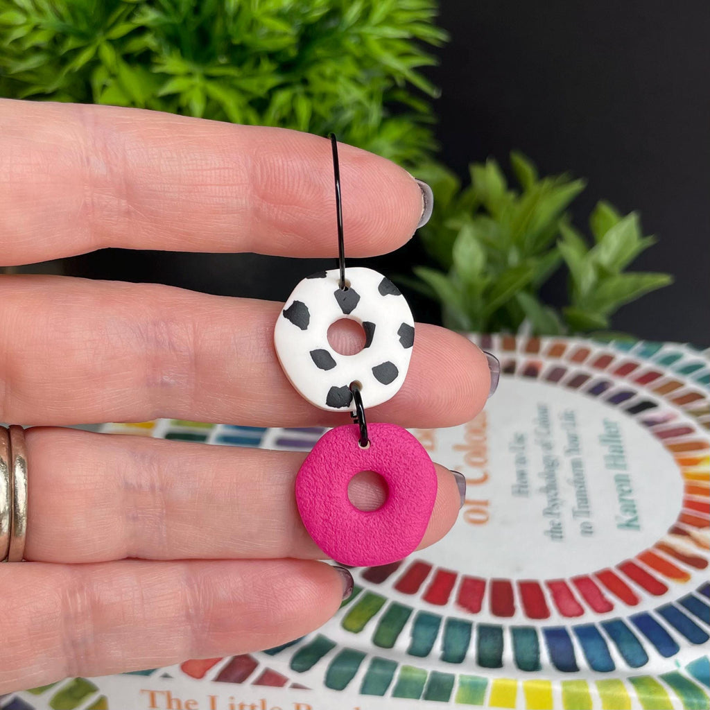 Hand holding a Hot pink Dalmatian print hoop earring