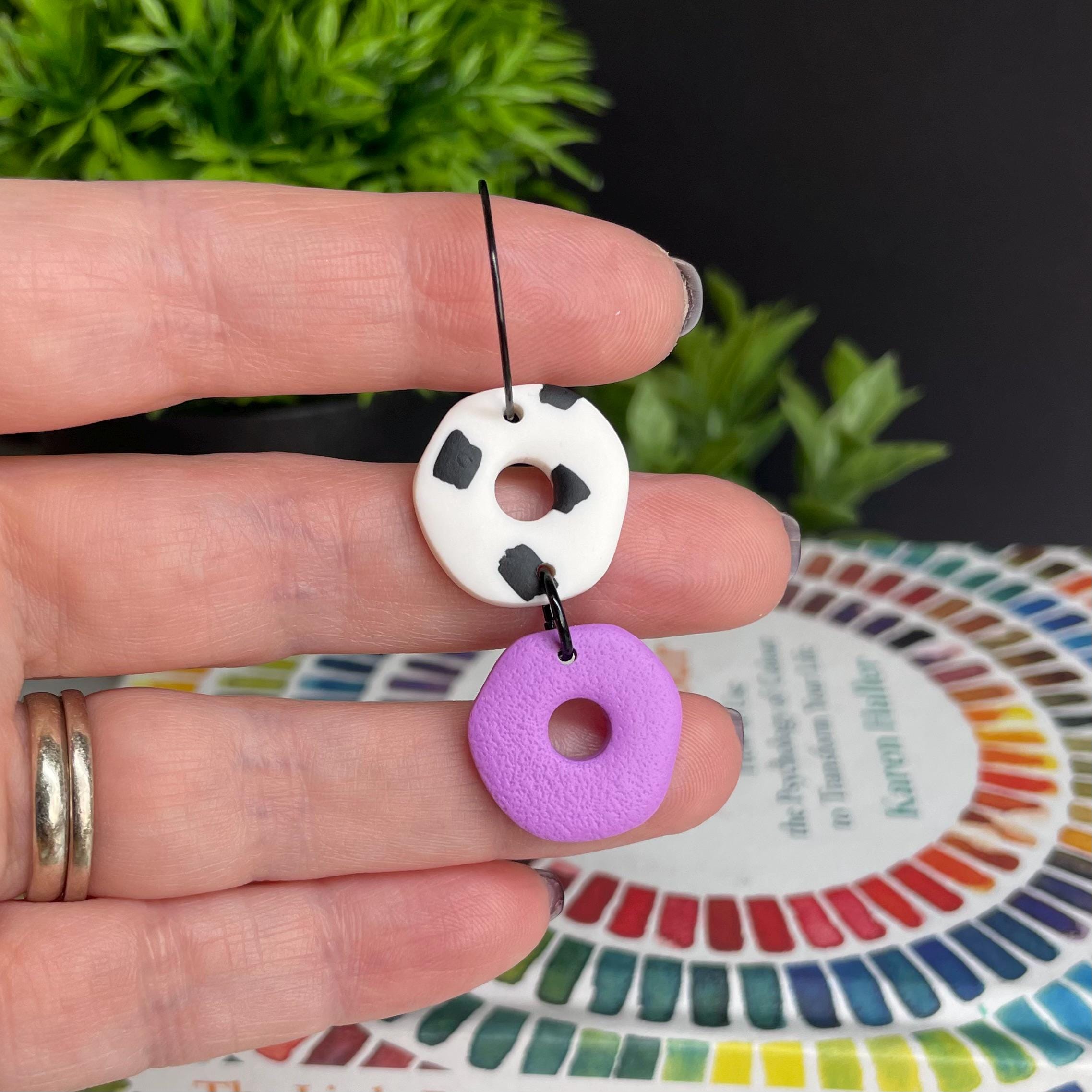 Hand holding a Lilac & Dalmatian print hoop earrings