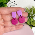 Lilac & Hot Pink colour pop dangle earrings held in hand for size reference