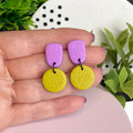 Lilac & Pistachio Green colour pop dangle earrings held in hand for size reference