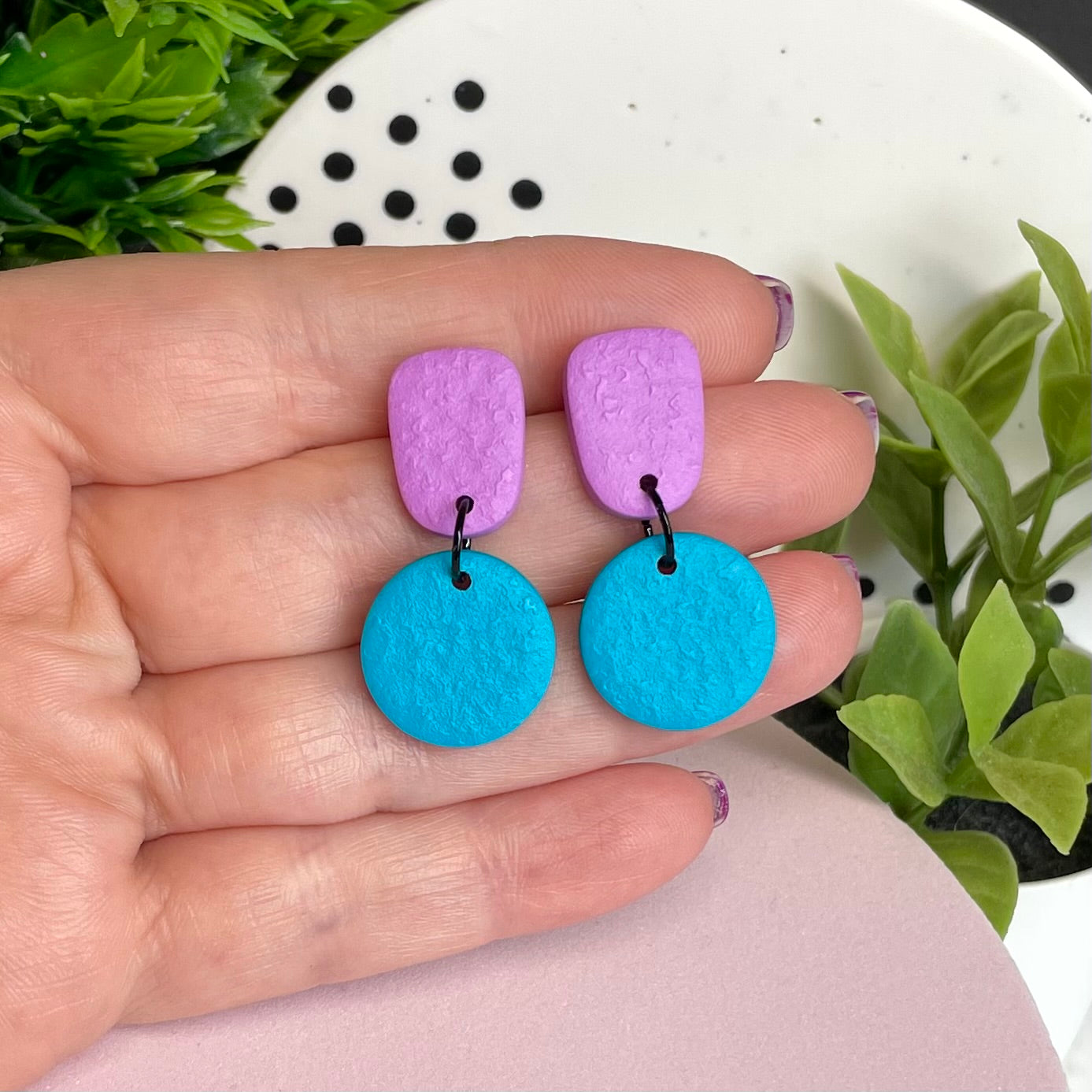 Lilac & Turquoise colour pop dangle earrings held in hand for size reference