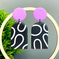Black and white squiggle patterned dangle earrings with lilac tops