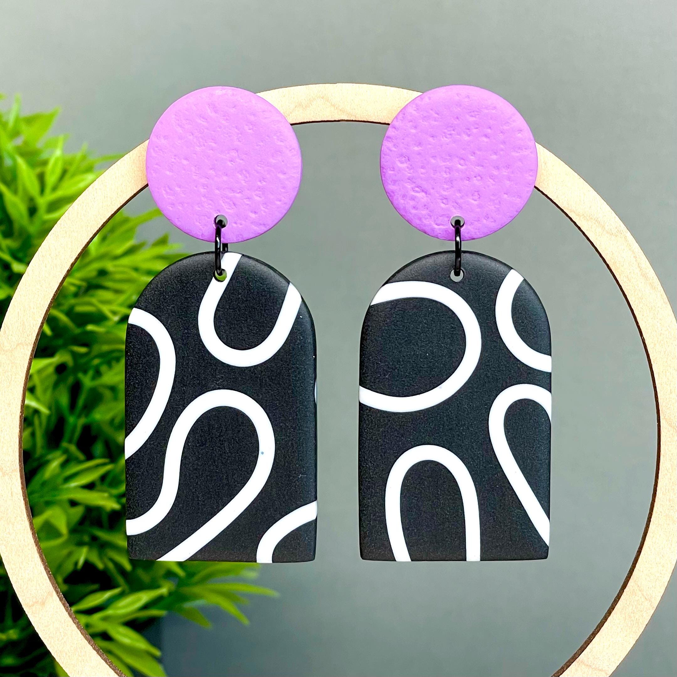 Black and white squiggle patterned dangle earrings with lilac tops