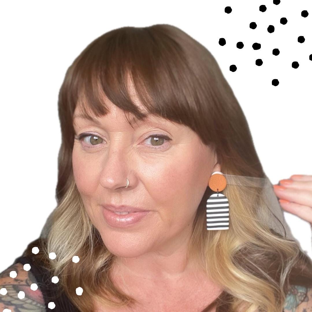 picture of Kerry from Kay Jay Clay wearing the Monochrome stripes dangle earrings with orange top for size reference
