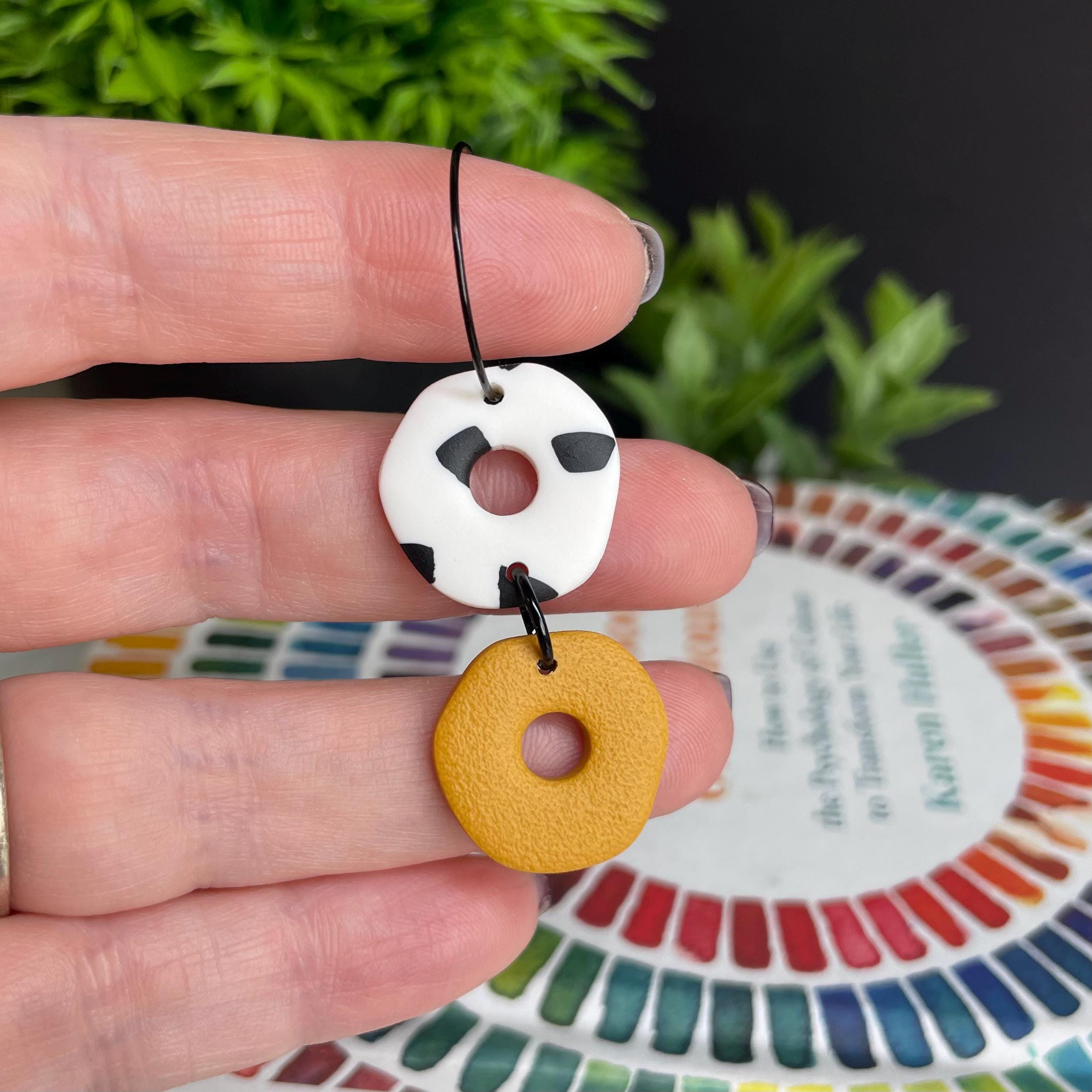 Hand holding a Mustard Yellow & Dalmatian print hoop earring