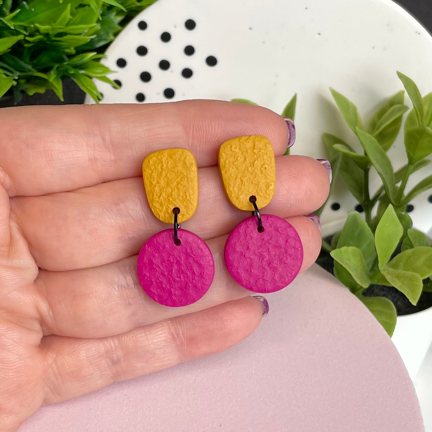Mustard Yellow & Hot Pink colour pop dangle earrings held in hand for size reference