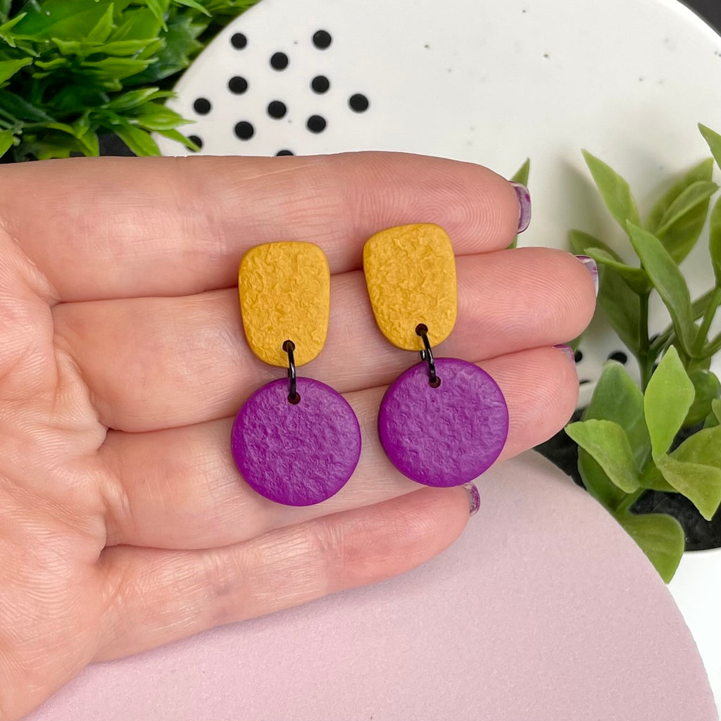 Mustard Yellow & Purple colour pop dangle earrings held in hand for size reference