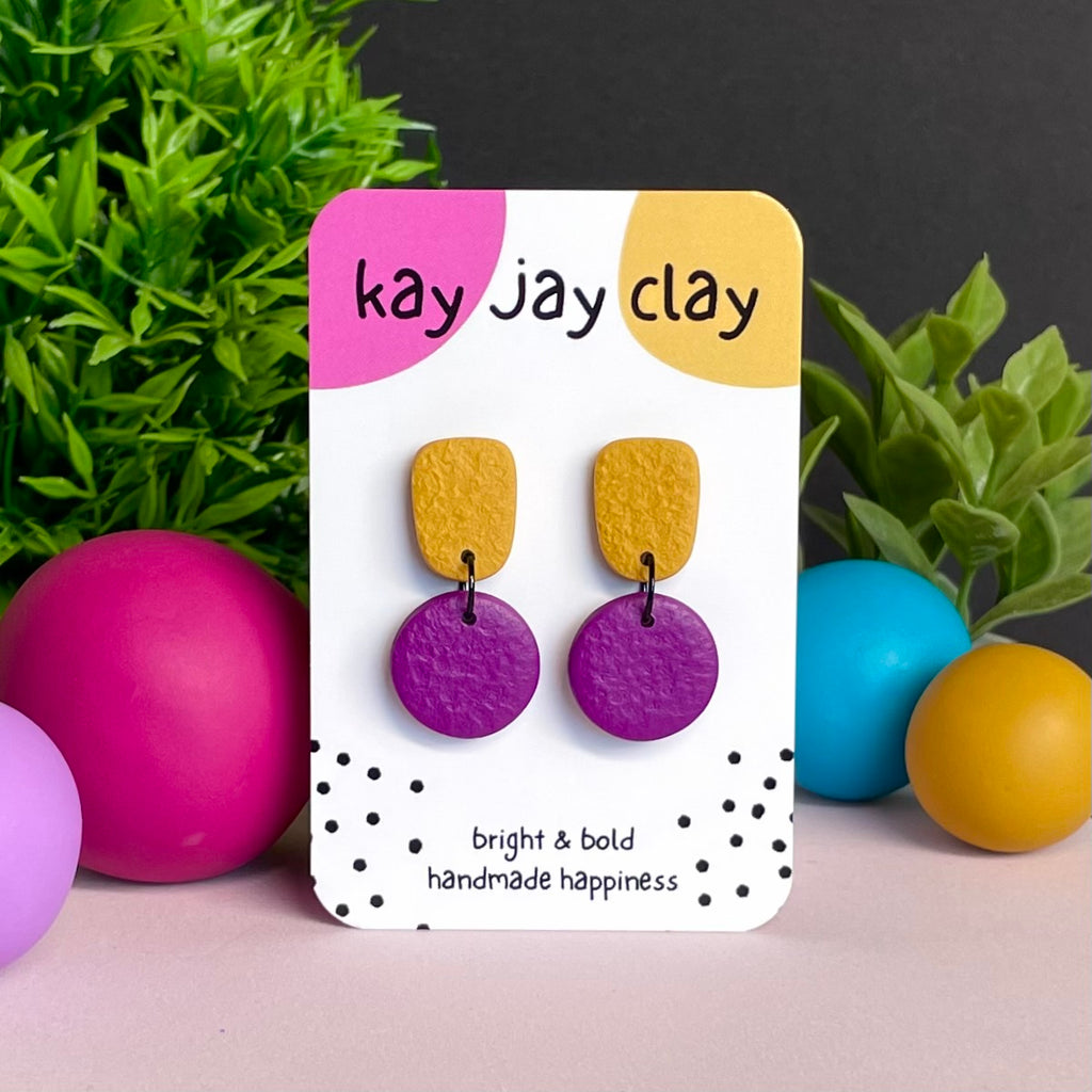 Mustard Yellow & Purple colour pop dangle earrings on Kay Jay Clay branded mounting card