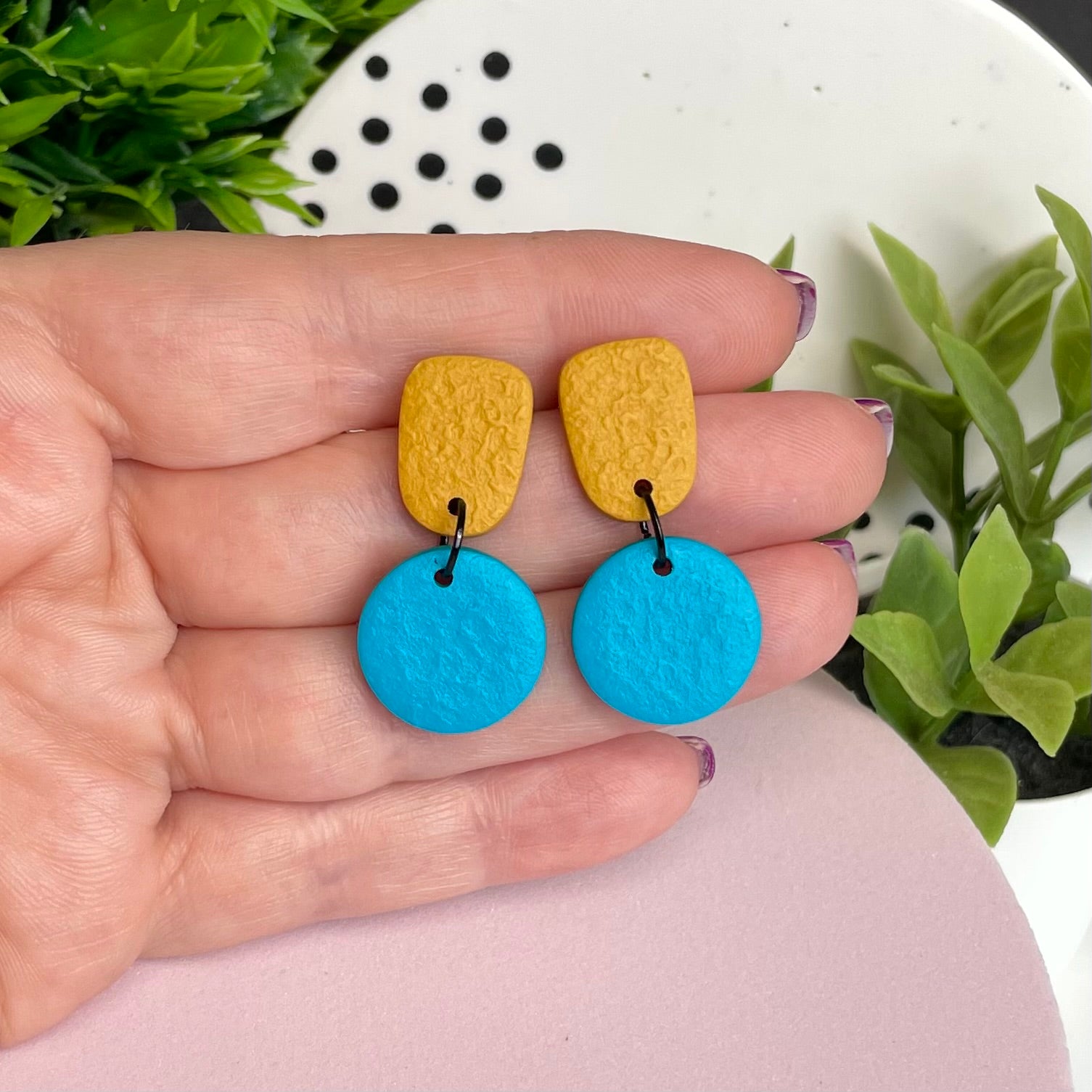 Mustard Yellow & Turquoise colour pop dangle earrings held in hand for size reference