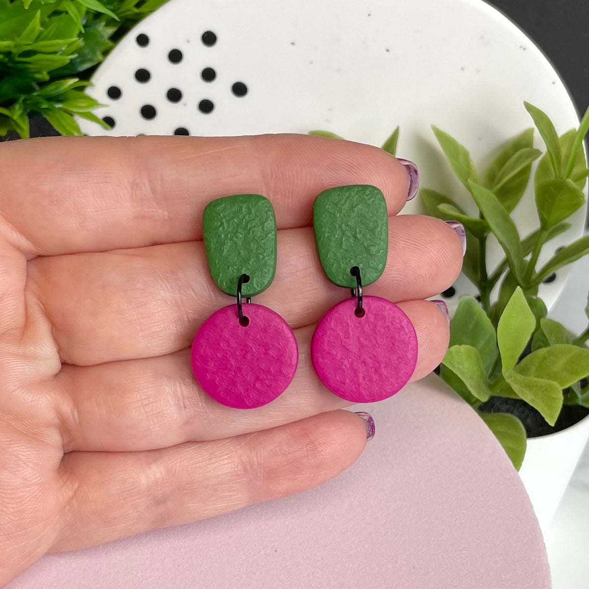 Olive Green & Hot Pink colour pop dangle earrings held in hand for size reference