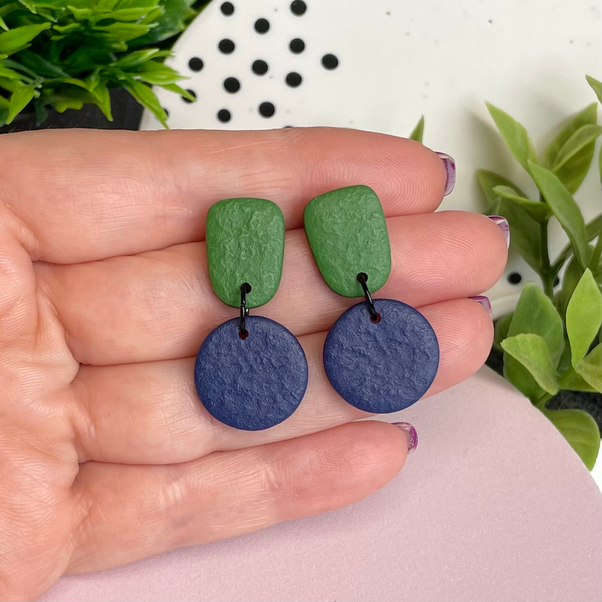 Olive Green & Navy Blue colour pop dangle earrings held in hand for size reference