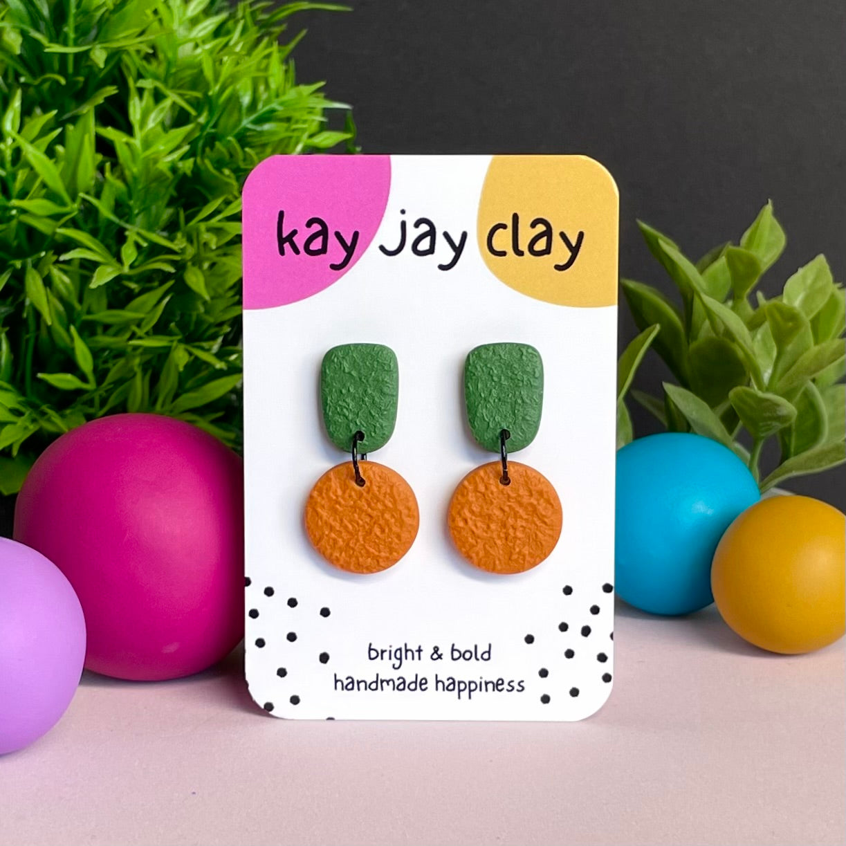 Olive Green & Orange colour pop dangle earrings on Kay Jay Clay branded mounting card