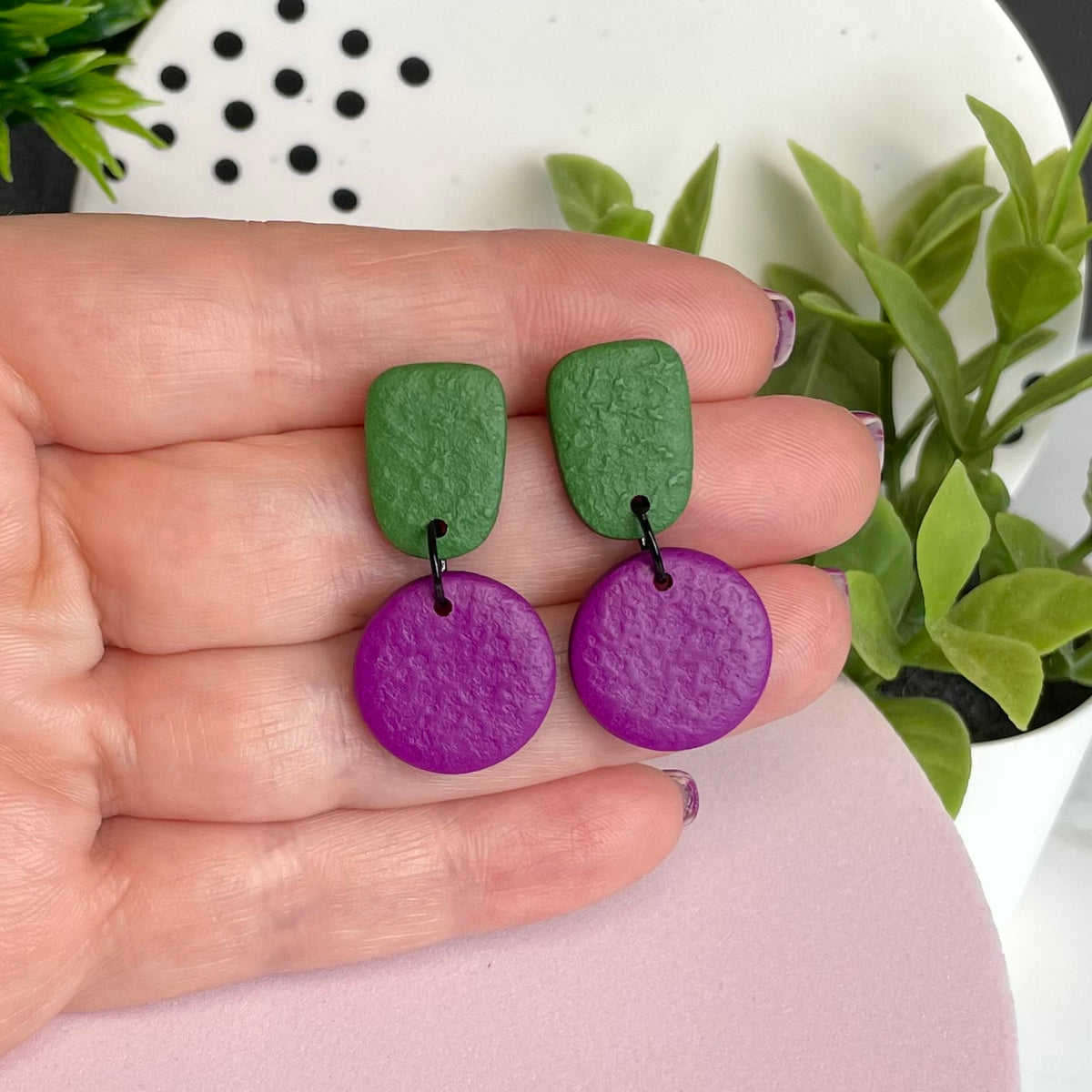 Olive Green & Purple colour pop dangle earrings held in hand for size reference