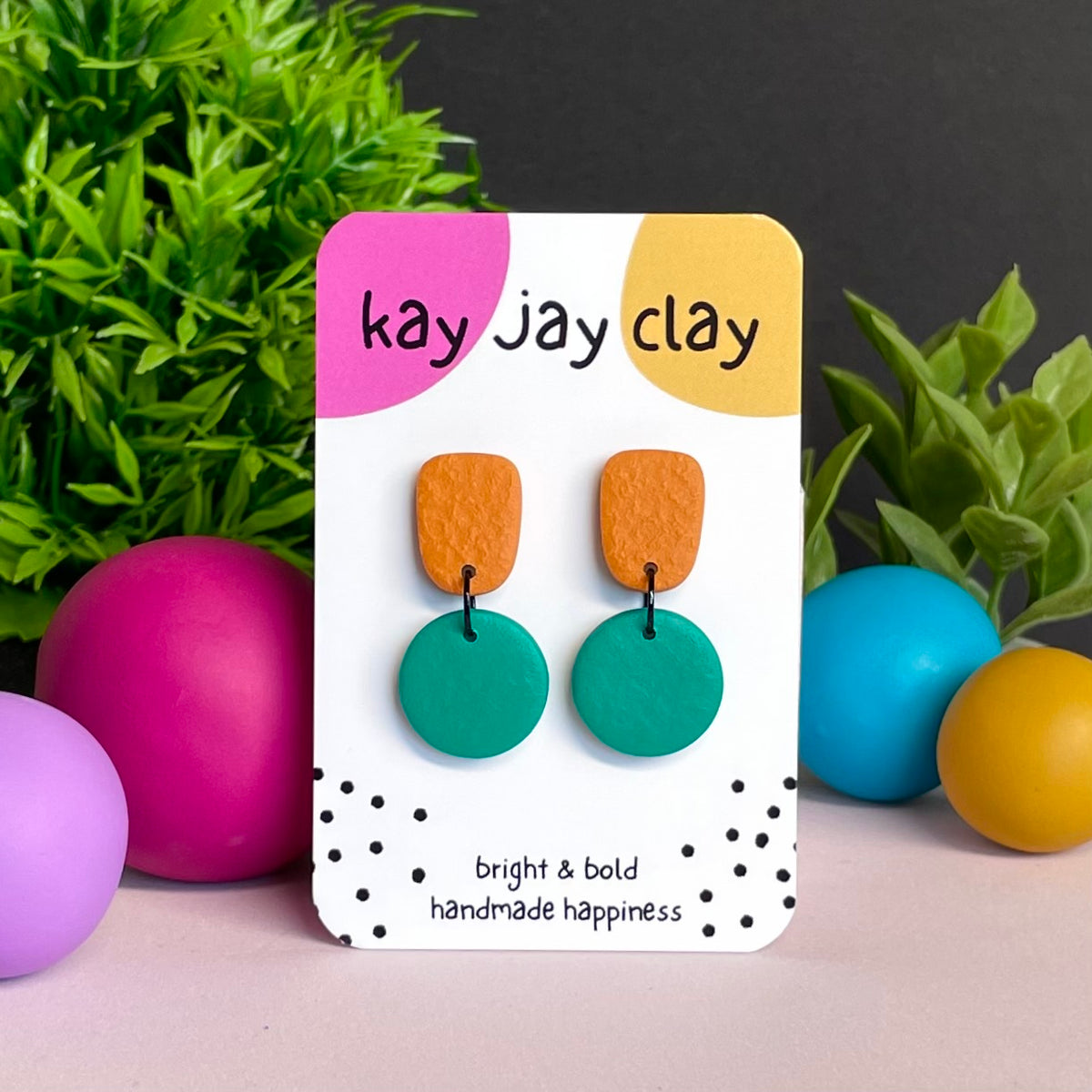 Orange & Emerald Green colour pop dangle earrings on Kay Jay Clay branded mounting card