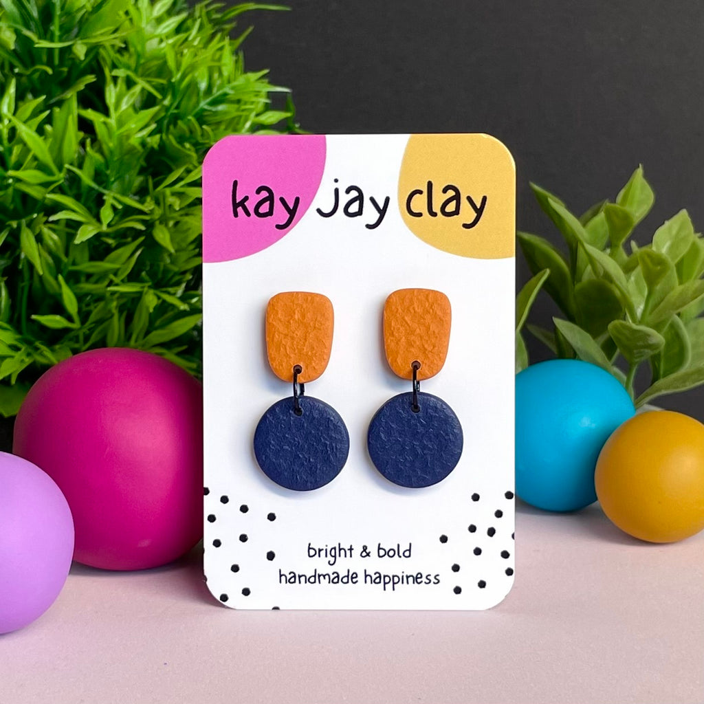 Orange & Navy Blue colour pop dangle earrings on Kay Jay Clay branded mounting card