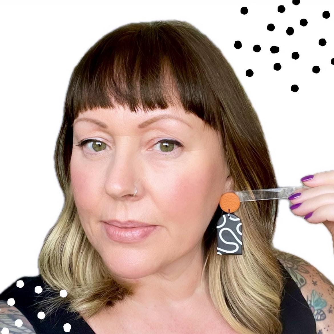 Try on picture of Kerry from Kay Jay Clay wearing the monochrome squiggle dangle earrings with a burnt orange top for size reference
