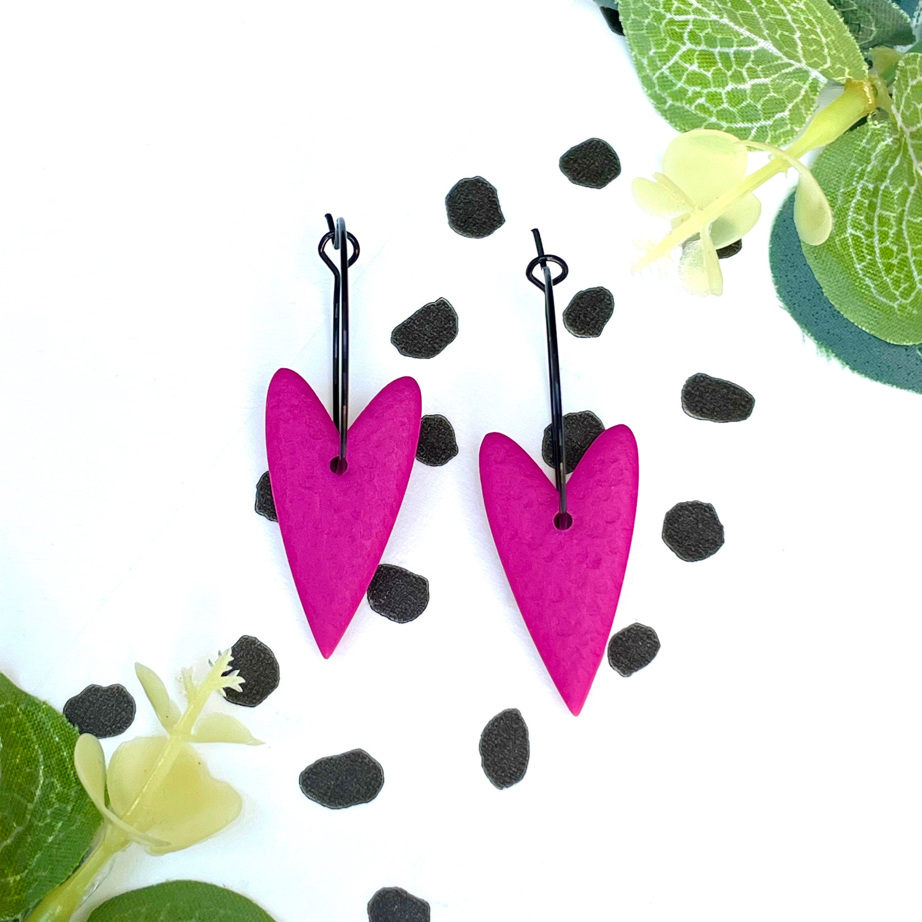 Hot pink heart-shaped earrings on a black colour hoop
