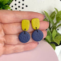 Pistachio Green & Navy Blue colour pop dangle earrings held in hand for size reference