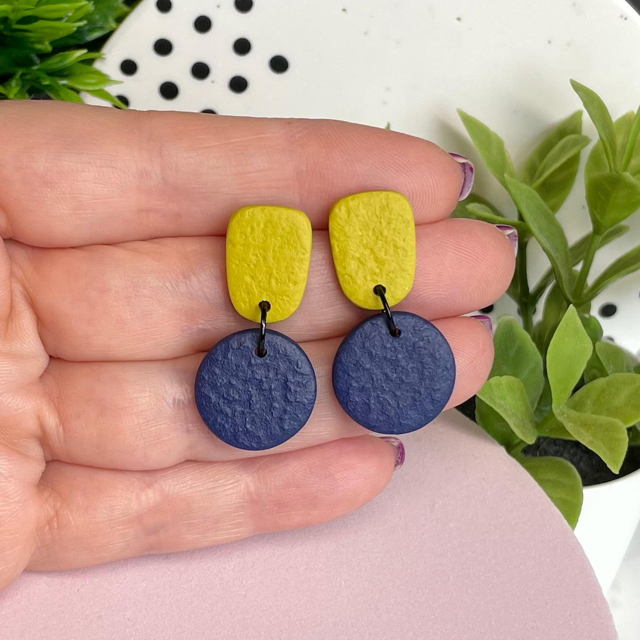 Pistachio Green & Navy Blue colour pop dangle earrings held in hand for size reference