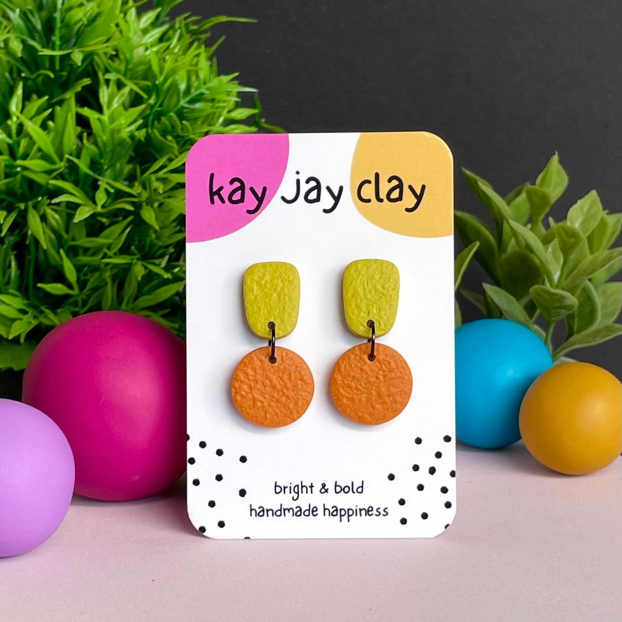 Pistachio Green & Orange colour pop dangle earrings on Kay Jay Clay branded mounting card