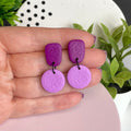 Purple & Lilac colour pop dangle earrings held in hand for size reference