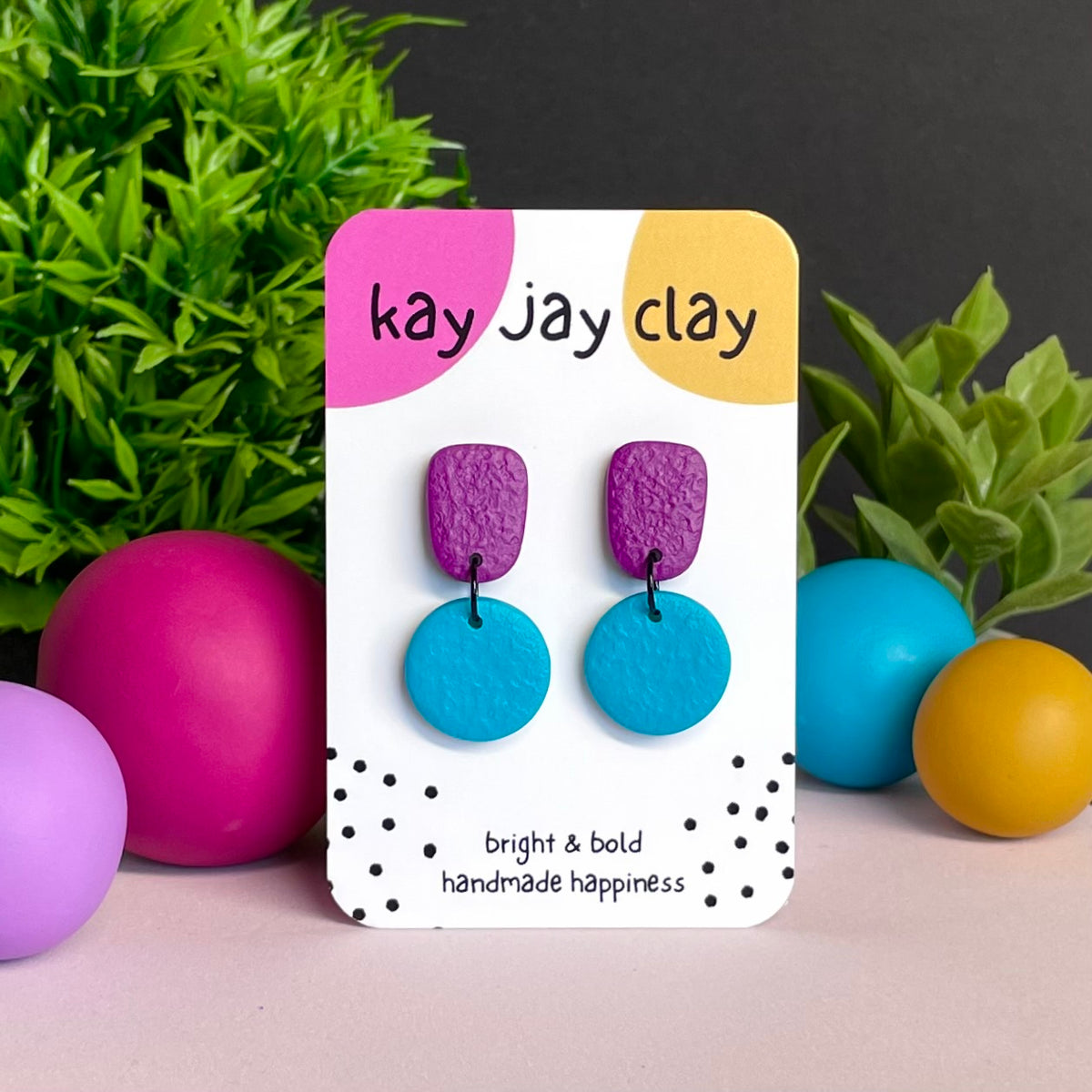 Purple & Turquoise colour pop dangle earrings on Kay Jay Clay branded mounting card