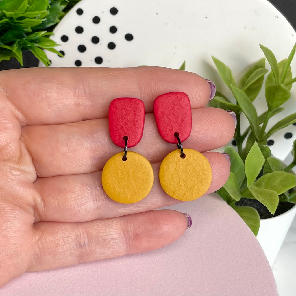 Red & Mustard Yellow colour pop dangle earrings held in hand for size reference
