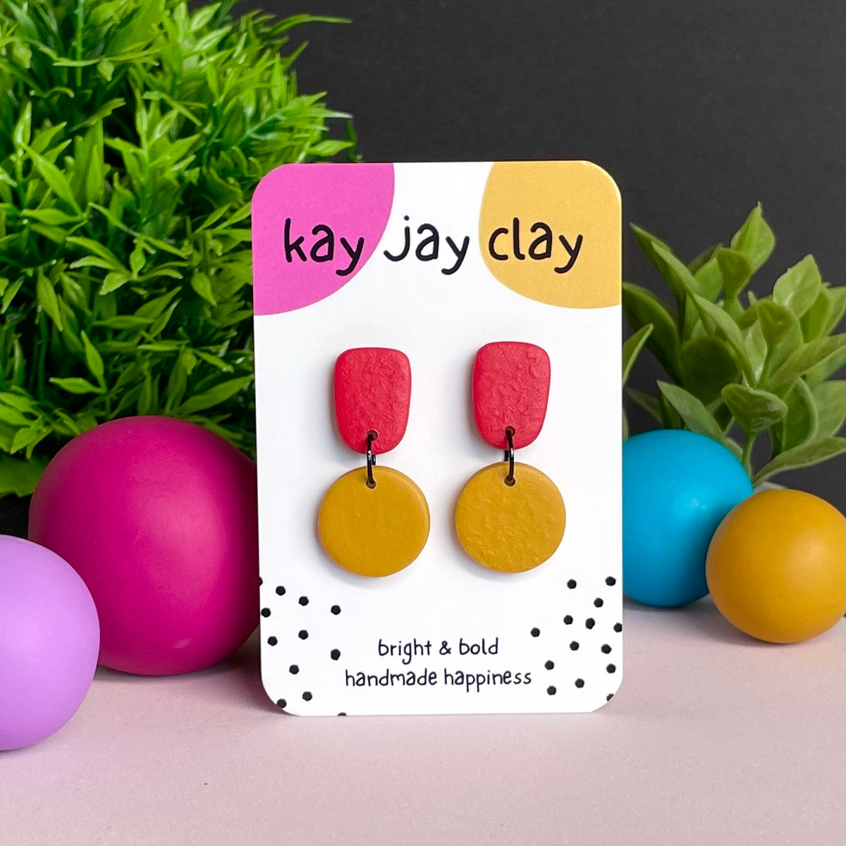 Red & Mustard Yellow colour pop dangle earrings on Kay Jay Clay branded mounting card