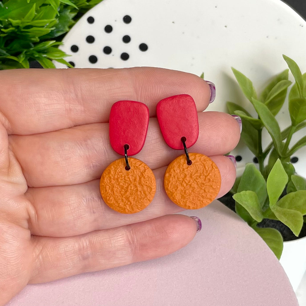 Red & Orange colour pop dangle earrings held in hand for size reference