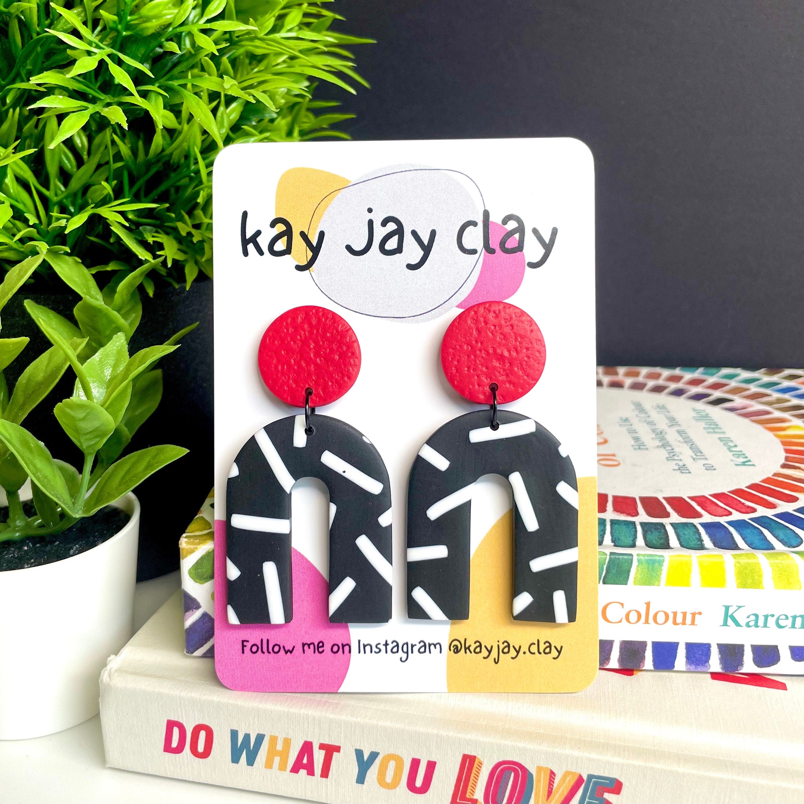 Red and monochrome sprinkles arch dangle earrings On a Kay jay clay mounting card