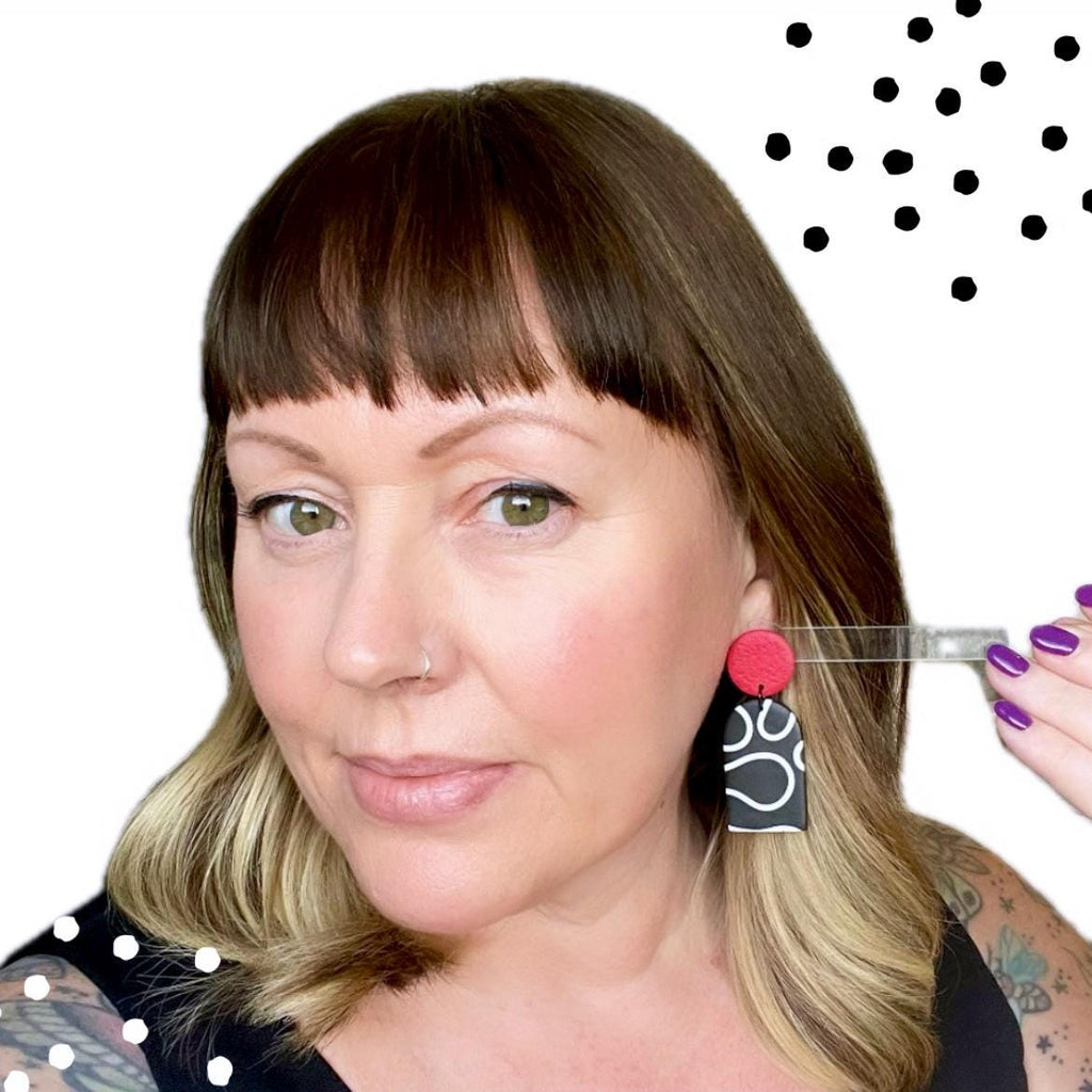 Try on picture of Kerry from Kay Jay Clay wearing the monochrome squiggle dangle earrings with red tops for size reference
