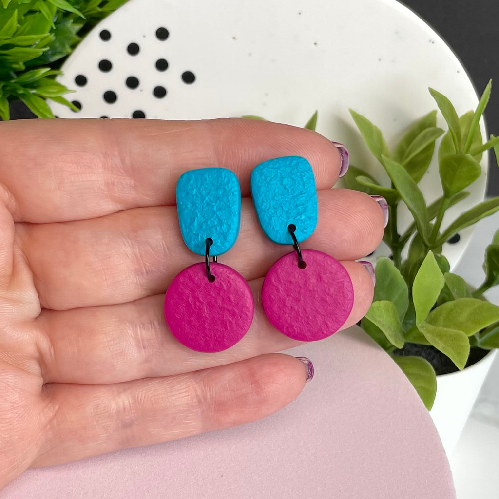 Turquoise & Hot Pink colour pop dangle earrings held in hand for size reference