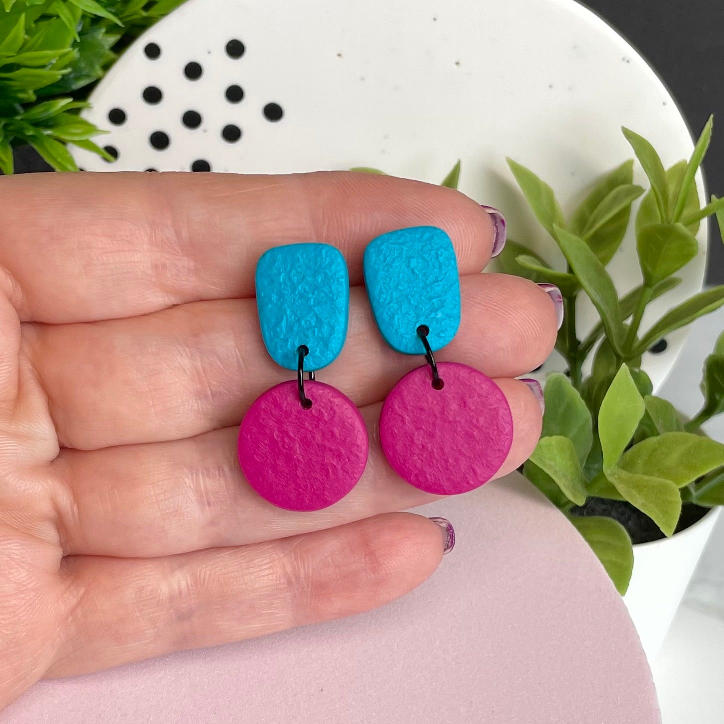 Turquoise & Hot Pink colour pop dangle earrings held in hand for size reference