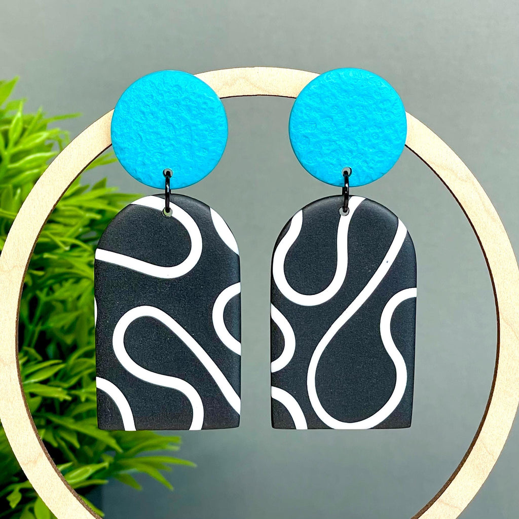 Black and white squiggle patterned earrings with turquoise circular tops