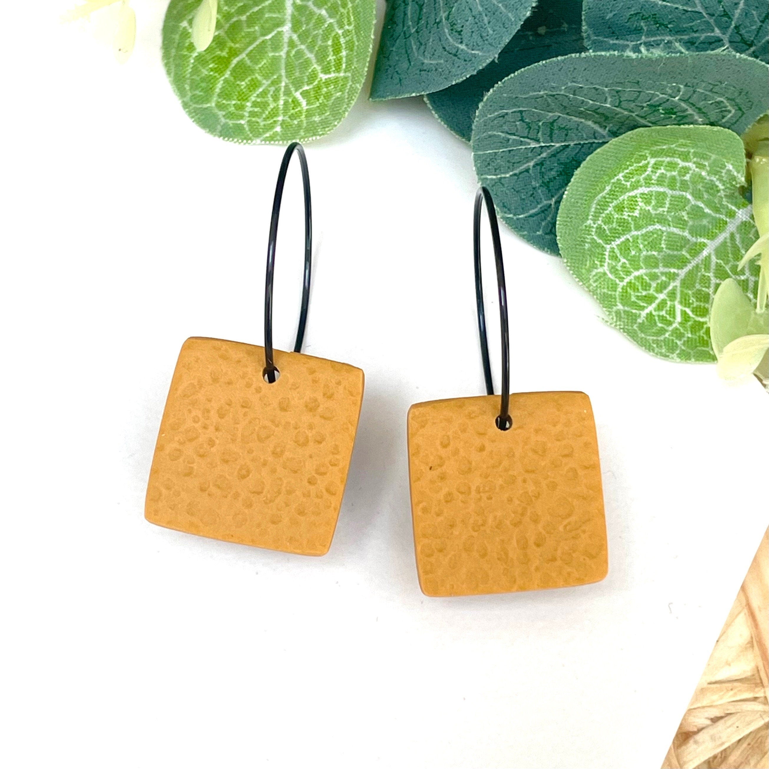 Mustard yellow square earrings on black hoops